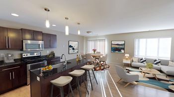 Angled view of the kitchen with stainless steel appliances leading into the living area.